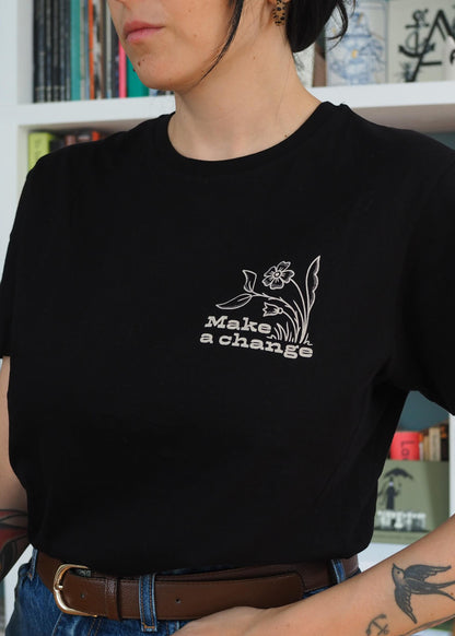 Close up of the screen printed 'Make a Change' eco-conscious graphic detail featuring a stylized flower on black cotton t-shirt